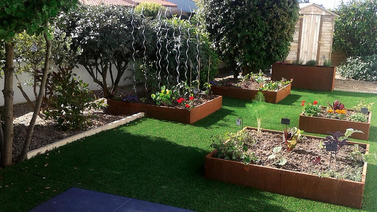 Photo montrant un jardin, pelouse et 3 carrés potager à partir de 3 bacs de jardin