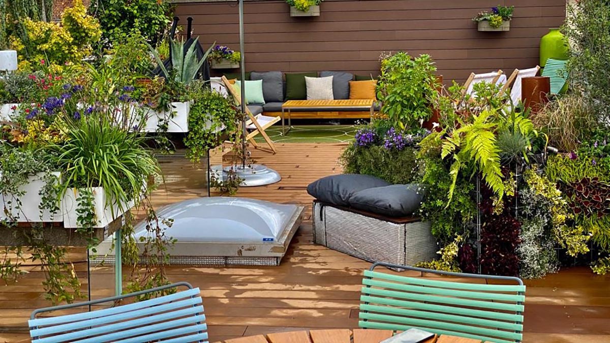 Vue d'une terrasse en bois sur le toit d'un immeuble avec une décoration chic et colorée